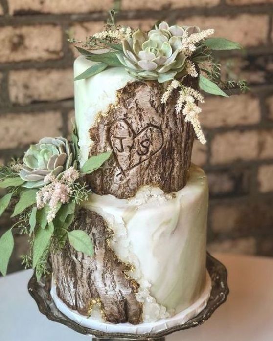 a catchy fall woodland wedding cake that imitates bark and green marble, greenery, succulents and foliage is a cool idea