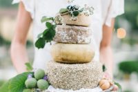 a cheese wheel cake with fresh fruits is a tasty alternative to a usual wedding cake for a couple who doesn’t love sweets