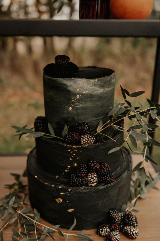 a chic and stylish black textural wedding cake with an ombre touch, gold leaf, blackberries and greenery for a Halloween wedding