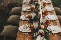 a classic Thanksgiving wedding tablescape with a greenery and bold blooms, tall and thin candles and colored glasses