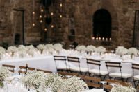 a classic Tuscany wedding tablescape with baby’s breath, candles and white linens is pure elegance