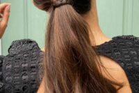 a cool low wavy ponytail with a sleek top and a braid wrapping it is a great idea for thick hair