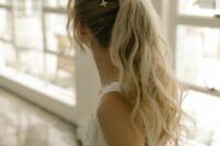 a cool messy and wavy high ponytail with a volume on top, some locks down, stars accenting the hairstyle