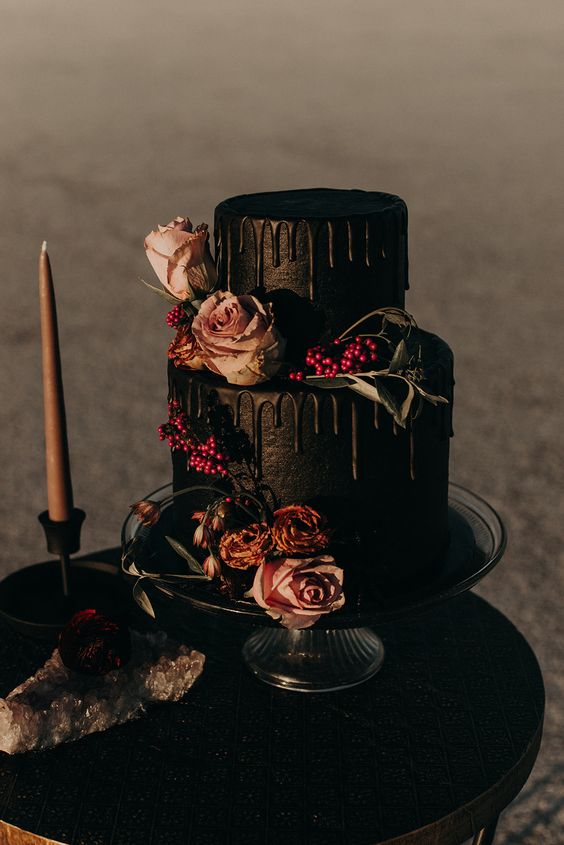 a decadent black wedding cake with drip, rust and blush blooms, greenery and berries is a fantastic idea for a Halloween wedding