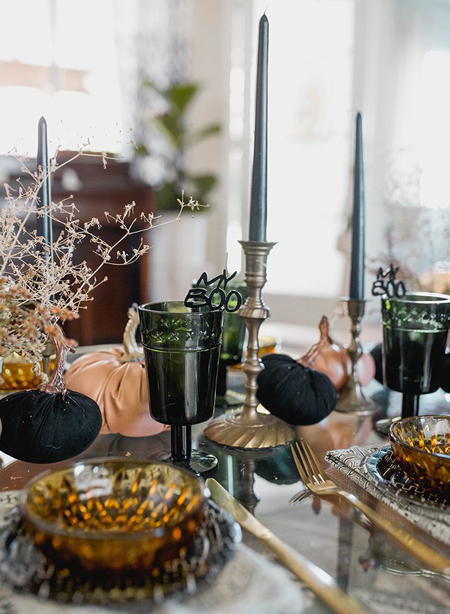 a fab Halloween bridal shower table setting with black and orange pumpkins, dried flowers, black tall and thin candles, amber glassware is wow