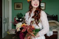 a fall woodland bride wearing a bright florla crown and carrying a matching super bold wedding bouquet with greenery and berries