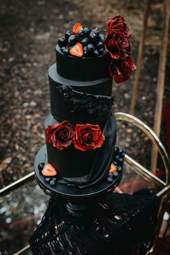 a fantastic black wedding cake with black sugar blooms and draperies, red roses and fresh berries on top is a lovely decadent idea that makes your mouth water