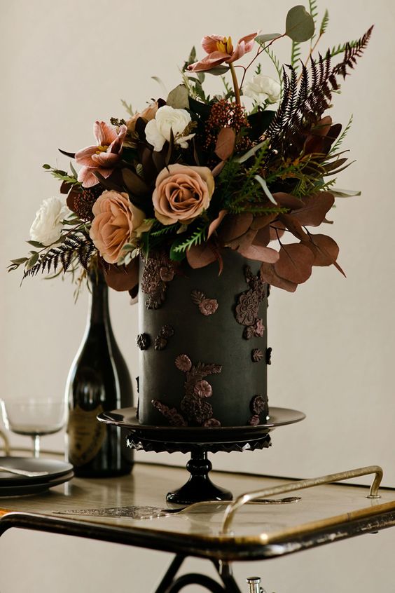 a fantastic black wedding cake with dark sugar florals and fresh white, rust and pink blooms, dark foliage and greenery for a fall wedding