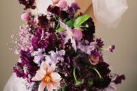 a fantastic textural wedding bouquet with lilac, pink and plum-colored blooms plus leaves and pink baby’s breath is very chic