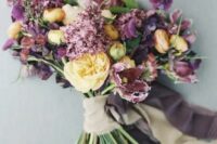 a gorgeous fall wedding bouquet of purple and burgundy blooms, yellow peony roses and greenery and neutral ribbon is a lovely idea