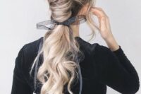 a gorgeous low chignon going into a long wavy pinytail and a sheer and etherel grey ribbon with a bow