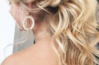a gorgeous low wavy ponytail with a messy bump and a twisted braid on the side is a trendy idea