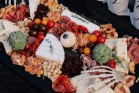 a great Halloween cheese board spiced up with skeleton hands and a large eyeball is a fantastic idea for a Halloween celebratiom