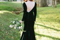 a hunter green velvet mermaid wedding dress with an open back, long sleeves and a train for a fall bride
