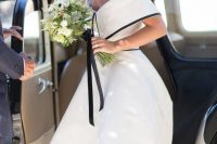 a jaw-dropping retro-inspired off the shoulder midi wedding dress with a black edge and a hat
