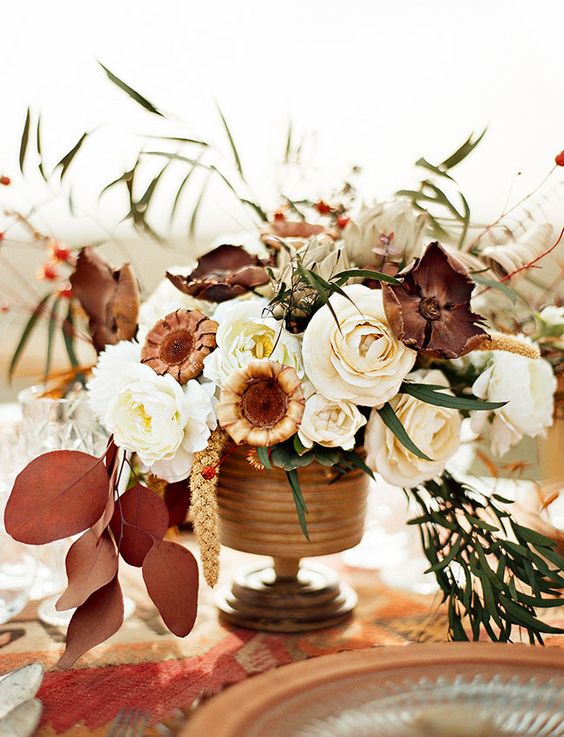a lovely Thanksgiving centerpiece of white, rust and burgundy blooms, dark foliage and greenery is amazing for your wedding
