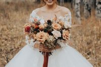 a lovely fall woodland wedding bouquet in rust shades, with rust and tan blooms, dark ones and some dried foliage is amazing