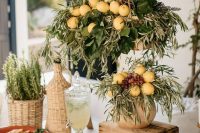 a lovely olive, citrus and cheese food station decorated with foliage, olive greenery and lemons