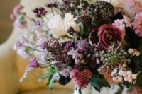 a lovely textural wedding bouquet with plum-colored, neutral, deep purple and pink blooms, berries and leaves is wow