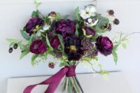 a lovely wedding bouquet with plum-colored and white blooms, berries, greenery and plum-colored ribbons is amazing