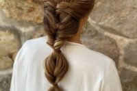 a low bubble ponytail with twists and a volume on top is a stylish idea for a refined and chic bridal look