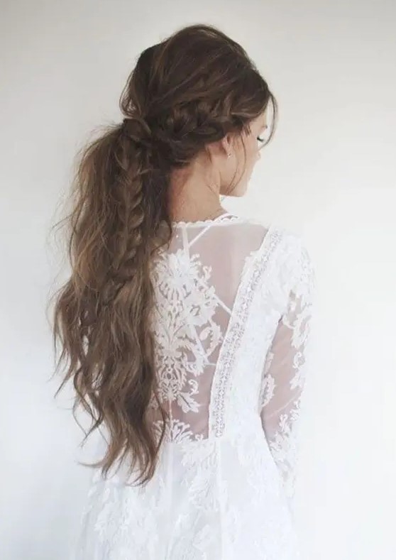 a low messy ponytail with a braid is ideal for a boho chic bride