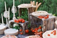 a mini pizza bar with various fresh veggies and herbs and lots of kinds of pizza for a Tuscany wedding