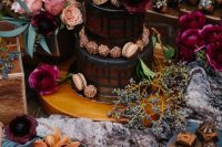 a moody dessert table with a naked cake, chocolate and cookies and fuchsia and pink blooms for a Halloween wedding or shower