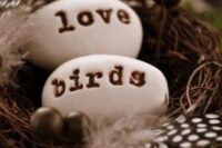 a nest with pebbles imitating eggs and feathers is a cozy and pretty decoration for a woodland or rustic wedding