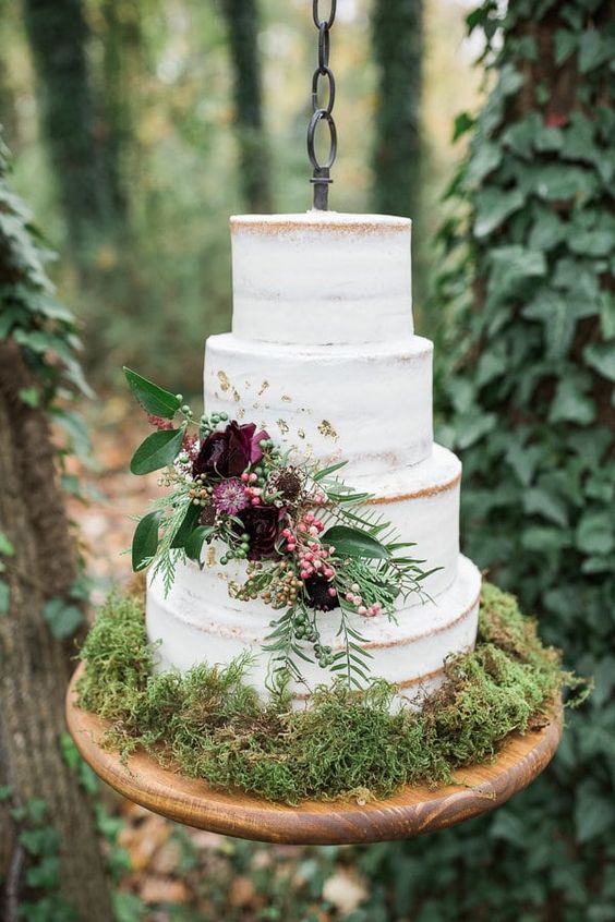 a pretty and delicate fall woodland wedding cake, a naked one with dark blooms, berries and leaves is a very chic idea