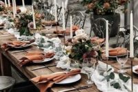 a refined Thanksgiving tablescape with a neutral runner, rust napkins, neutral and pink blooms and tall candles is amazing