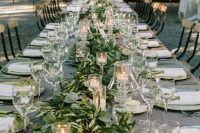 a romantic Tuscany wedding reception with greenery, candles and candle lanterns over the tables