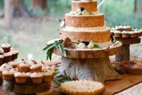 a rustic sweets table with tree slices and tree stumps, greenery, pinecones and lots of delicious sweets