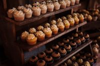 a rustic wooden sweets stand with lots of cupcakes is a very cool and simple idea