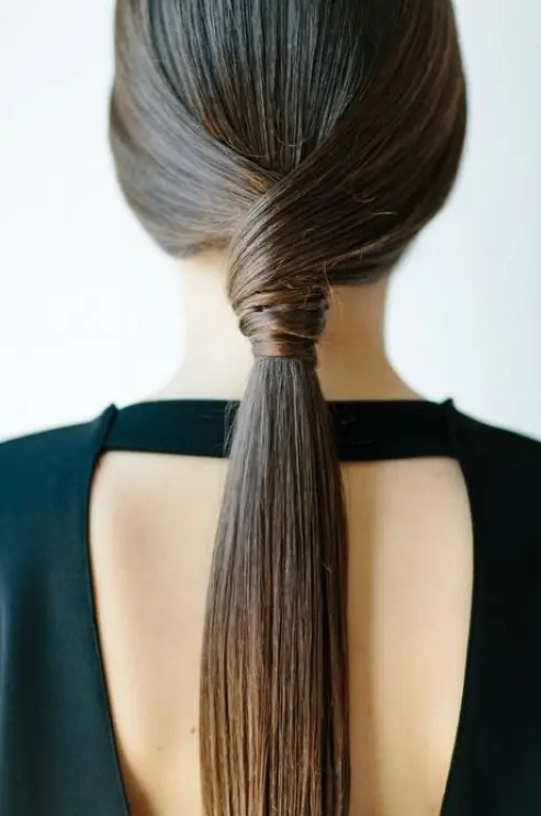 a sleek twisted low ponytail is a stylish idea for a modern or minimalist bride