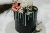 a small and pretty black wedding cake with creamy drip, white and pink blooms and greenery is a lovely idea for a modern wedding