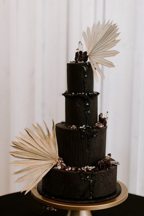 a sophisticated and inspiring black wedding cake with berries, black drip, dried fronds and glitter will be a bold solution for a moody boho wedding