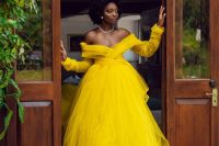 a sunshine yellow off the shoulder wedding ballgown with long sleeves and a statement crown for a wow effect