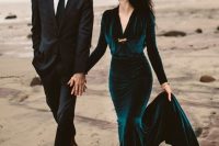 a teal velvet mermaid wedding dress with a V-neckline and long sleeves plus a train for a fall wedding