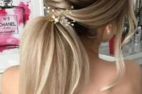 a twisted low ponytail with a volume, some locks down and a pretty hairpiece with crystals