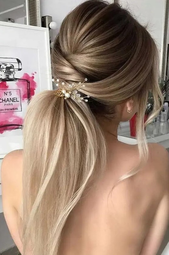 a twisted low ponytail with a volume, some locks down and a pretty hairpiece with crystals