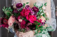 a vibrant wedding bouquet of plum, hot pink, deep purple and light pink blooms and greenery for a bold wedding