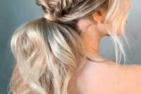 a wavy low ponytail with a bump on top, a braided halo and locks framing the face is a nice boho or rustic wedding hairstyle