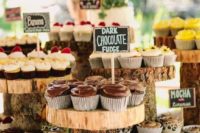 a wedding cupcake bar with wood slice stands and chalkboard tags is a cozy rustic idea for your fall wedding
