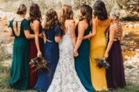 amazing mismatching maxi bridesmaid dresses in emerald, teal, electric blue, deep purple and marigold for a trendy fall bridal party look