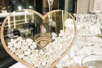 an alternative wedding guest book shaped as a heart, with little hearts with wishes is a cool idea for a modern rustic wedding