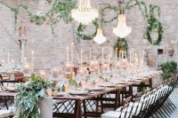an amazing Tuscany wedding reception with lots of candles and greenery, chandeliers over the tables