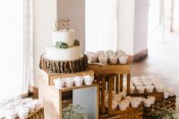 an easy rustic sweets display of crates, with baby’s breath and cupcakes and a cake with succulents