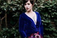 an electric blue velvet wedding dress with draperies and long sleeves plus a plunging neckline and a crystal headpiece