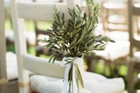 highlight the wedding chairs with olive branches with a lace bow